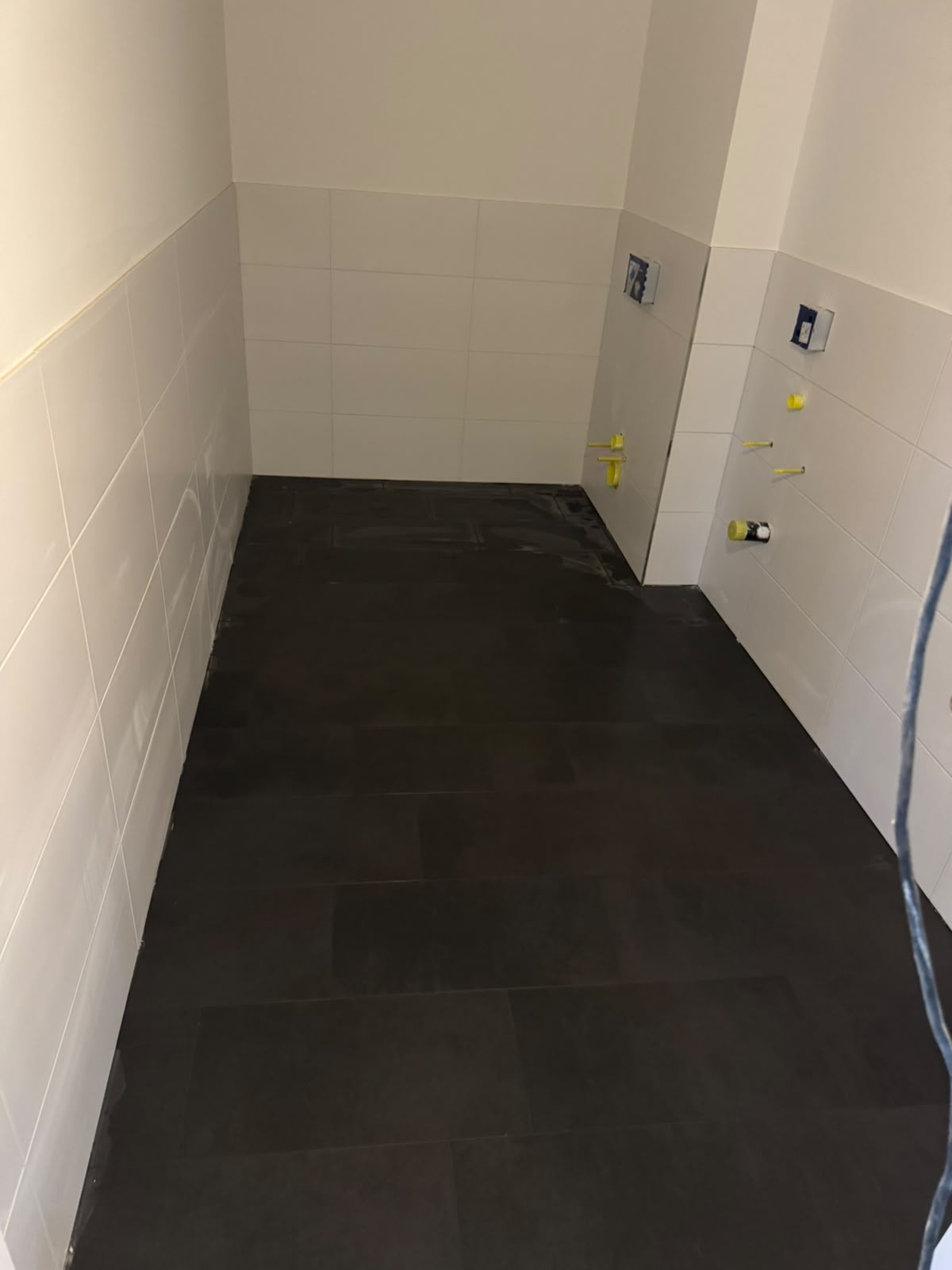Badezimmer mit Anthrazitboden & weißen Wandfliesen
